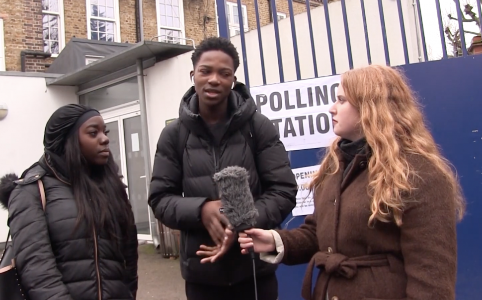 Journalist talking to two first time voters outside a polling station in Kensington