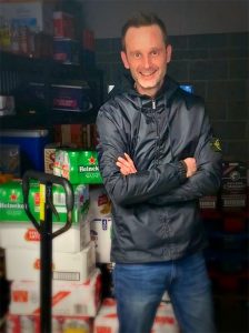 Ashleigh Fletcher, founder and co-director of Booze Up stands next to crates of beer