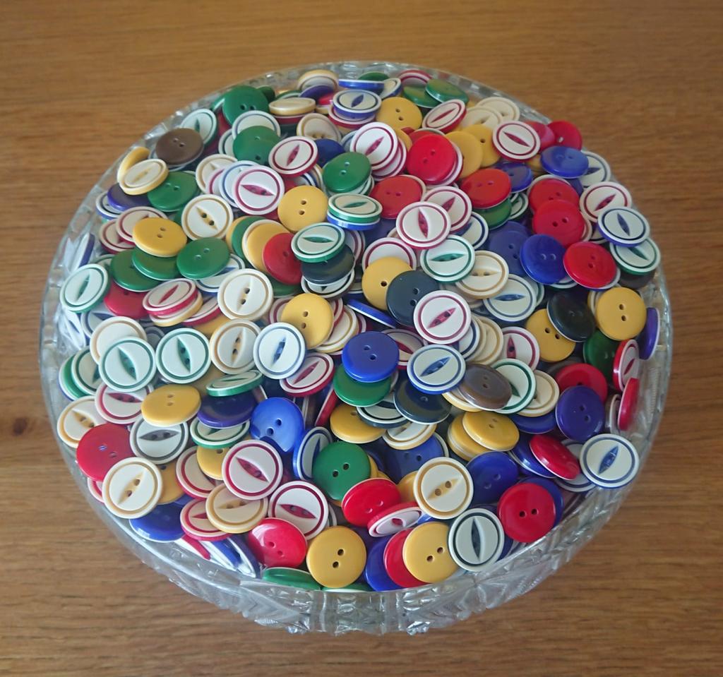 A large glass bowl full of buttons.