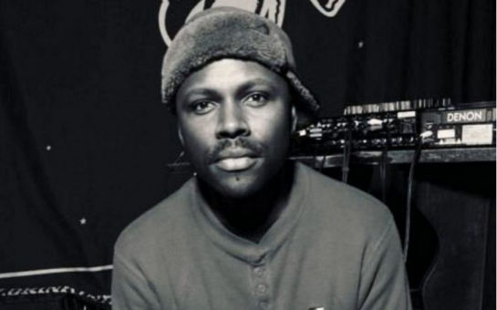 A black and white photo of Mr Gee. He is wearing a furry hat and is pouting at camera.