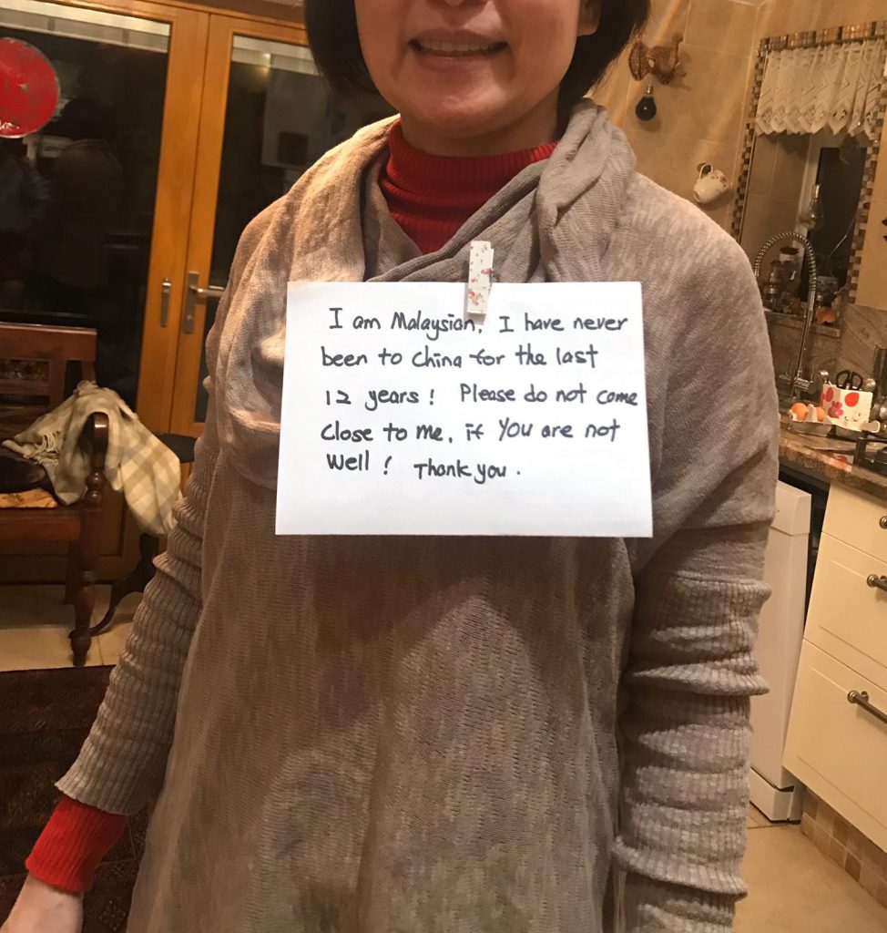 Julia Chantry poses with a placard which reads: "I am Malaysian. I have never been to China for the last 12 years! Please do not come close to me if you are not well! Thank you."