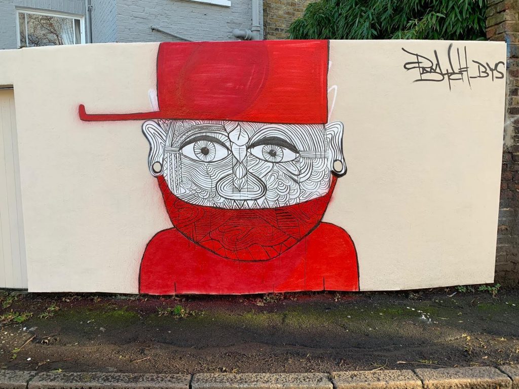 Psych's anti-knife mural on Stockwell Lane. The painting is of a man in a red mask and hat. There are lines all over his face, signifying identity.