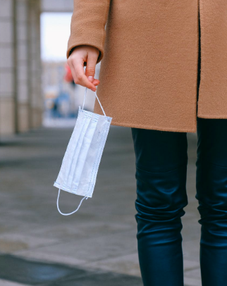 A woman holding a facemask.