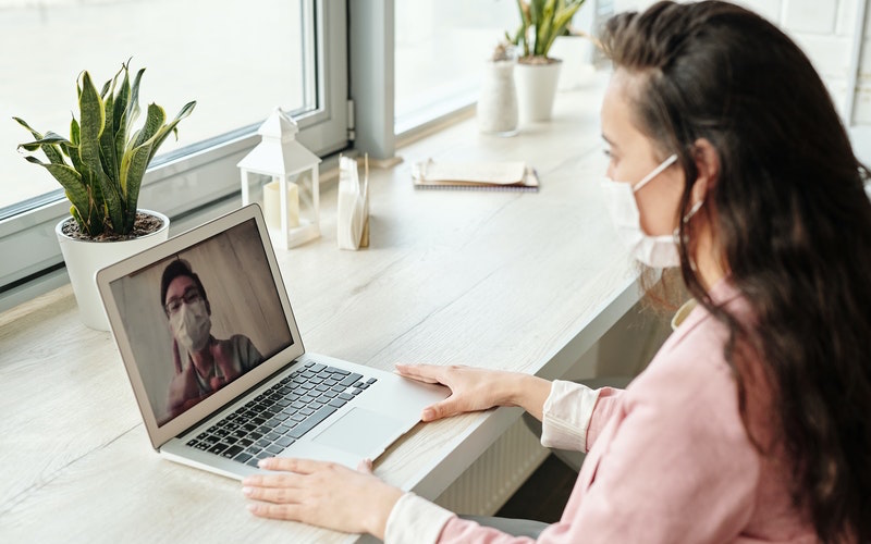 A woman video calls a man - both are wearing face masks