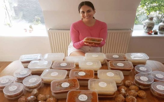 Jojo Sureh, head of Cook to Care in front of multiple tubs of food ready to be sent out