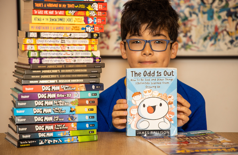 £5 million in library fines across London as 10-year-old Nicholas Hampartsoumian with a selection of books