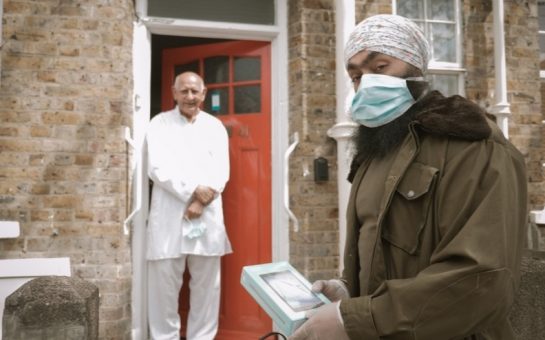 Ready Tech Go volunteer gives a device to an older resident