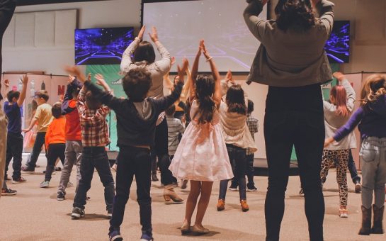 children participating in a physical activity with teachers