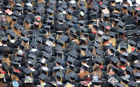 Crowd of students in graduation gowns taken from above, so you can see their mortarboards