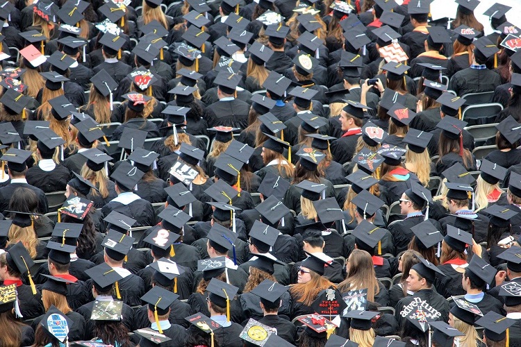 Crowd of students in graduation gowns taken from above, so you can see their mortarboards