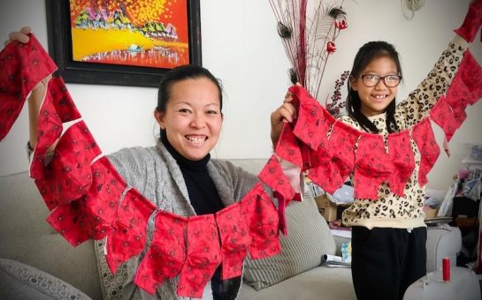 Mum and daughter hold poppy face masks