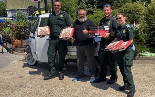 Peppe and ambulance workers holding pizzas outside