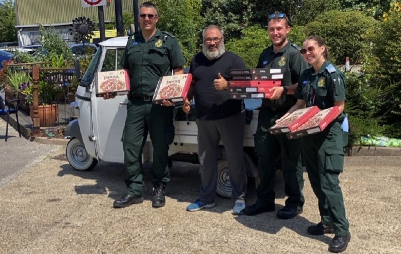 Peppe and ambulance workers holding pizzas outside