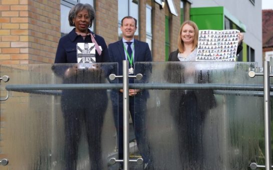 Yvonne Davis presents black history book and poster to Balham Head-Teacher Christian Kingsley alongside donator Carly Lewis