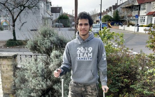 jonnas guerra with his crutches in front of his house