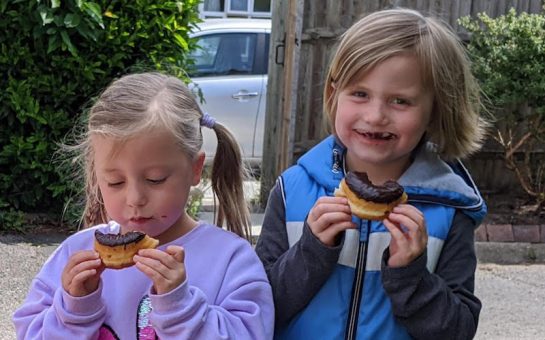 A picture of happy children eating doughnuts