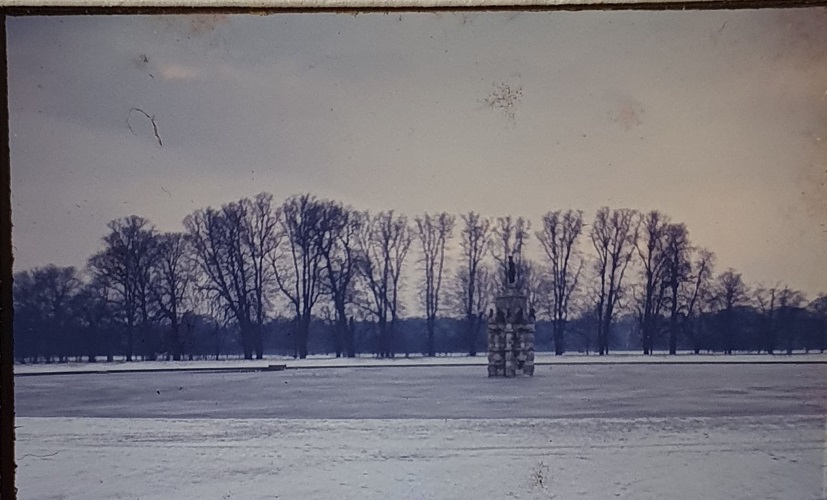 A snowy scene featuring the lake and Diana statues in bushy park