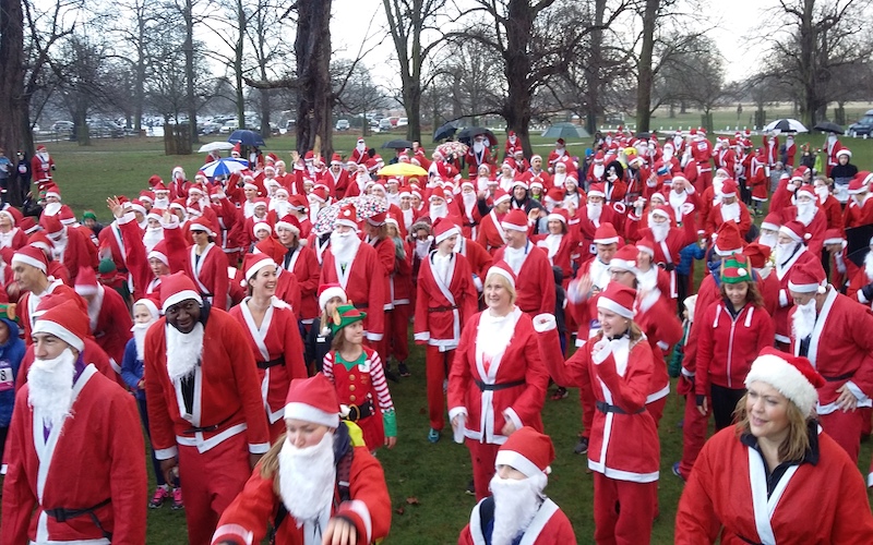 Hundreds of runners dressed in Santa costumes in Bushy Park for 2019 fun run.