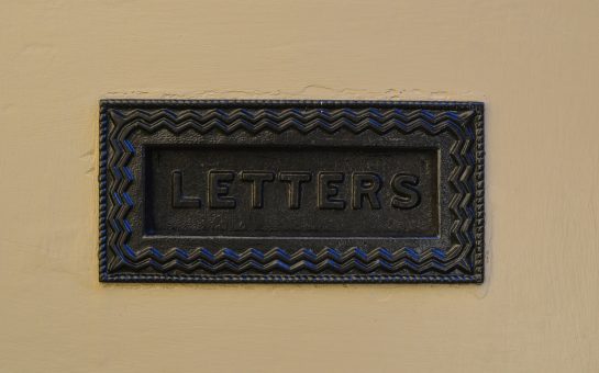 a bronze coloured postbox with the word letters embossed on it