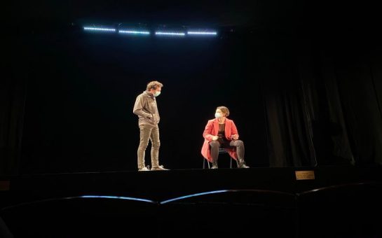 Carmel Skinner on the right, performing wearing a mask