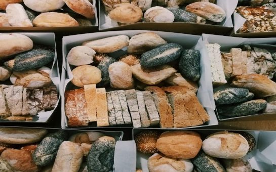 Hampers of various types of bread, including poppy seed rolls and slices of different loaves