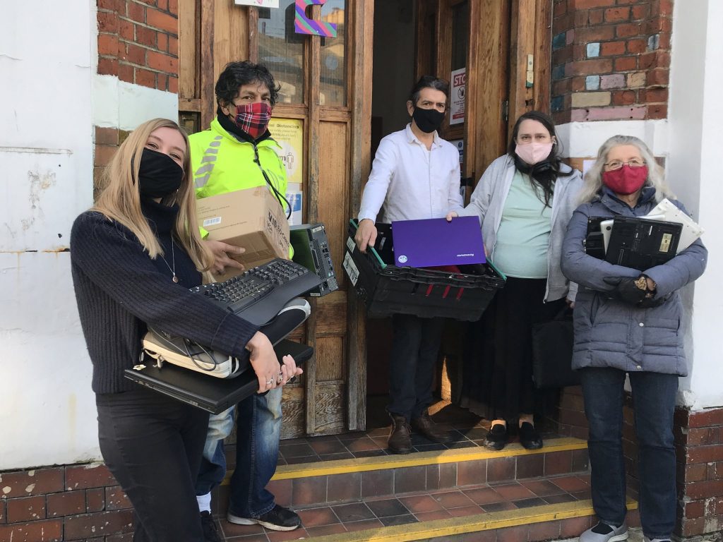 Members of Lambeth TechAid holding computers