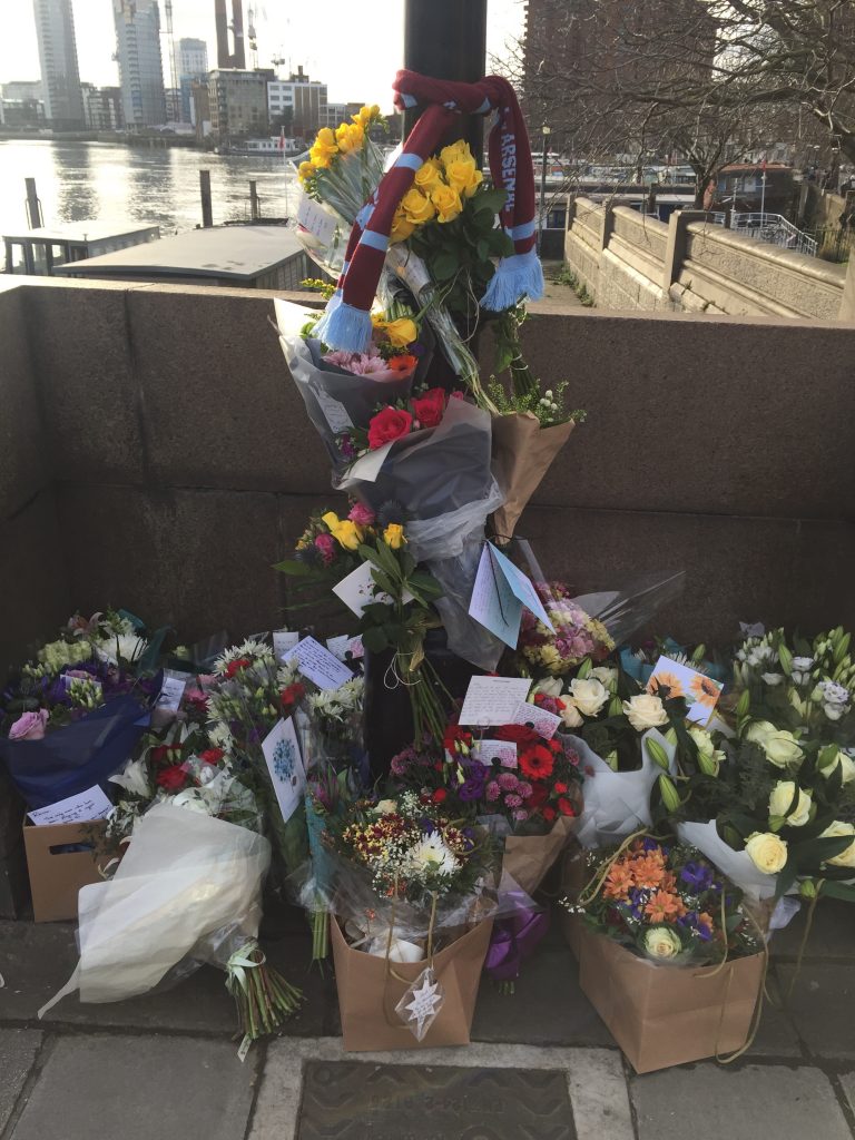 An image of flower tributes tied to a lamppost that were left for Mr Ryan on Battersea Bridge.