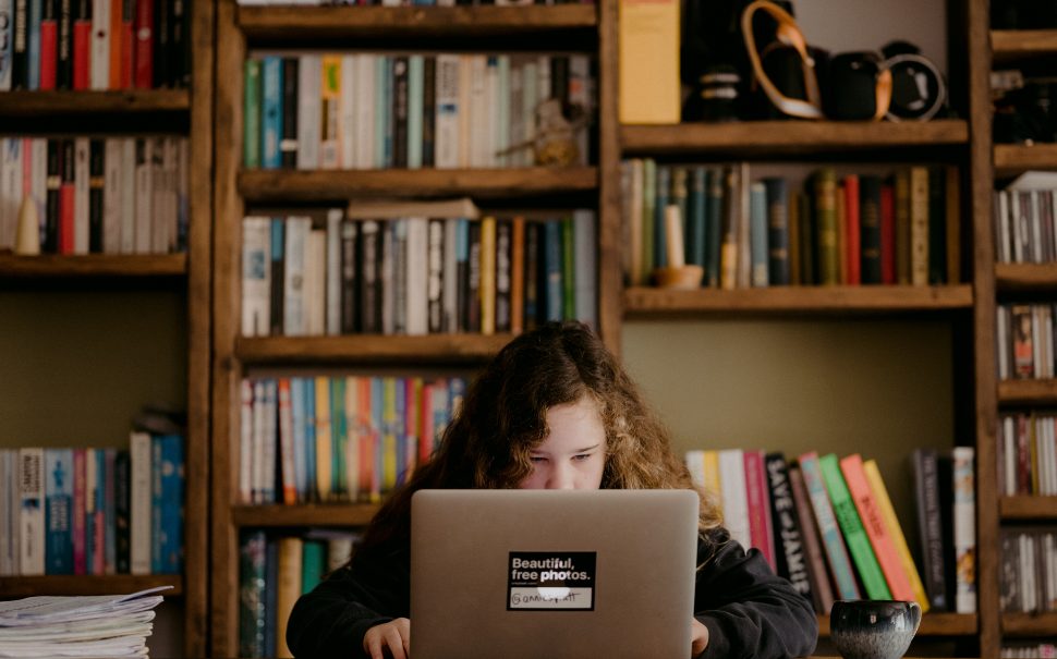 child with laptop on desk working
