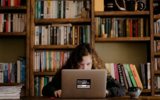 child with laptop on desk working