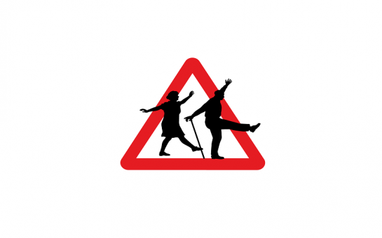 Read triangle road sign, with two elderly people dancing across the sign. The man has a walking stick