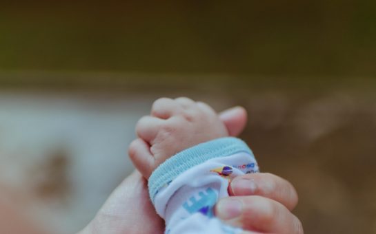 mother's hand holding baby's hand