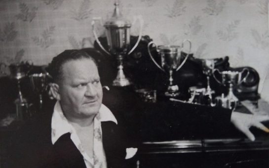 wrestler chick knight sits in front of his trophy collection
