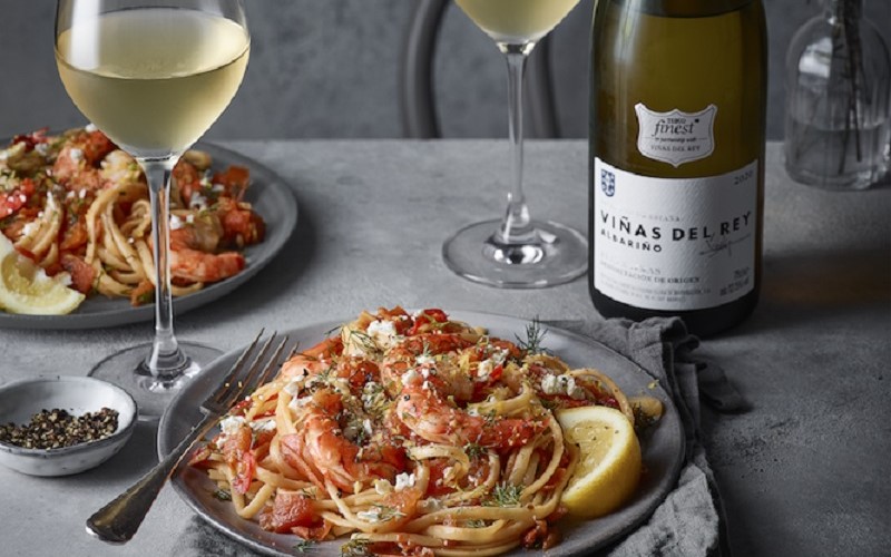 Two plates of spaghetti with two glasses of wine
