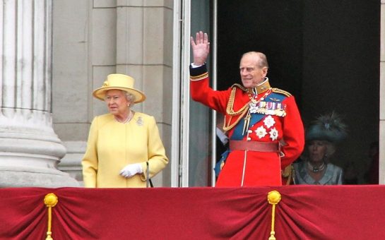 Prince Philip waving beside the Queen
