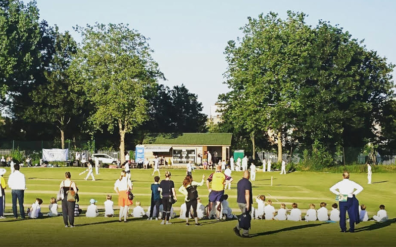 A junior team playing cricket in Acton
