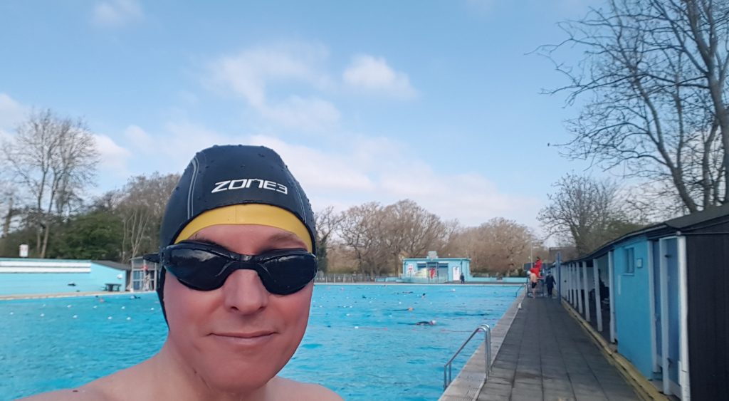 Swimmer wearing swimming hat enjoys Tooting Lido