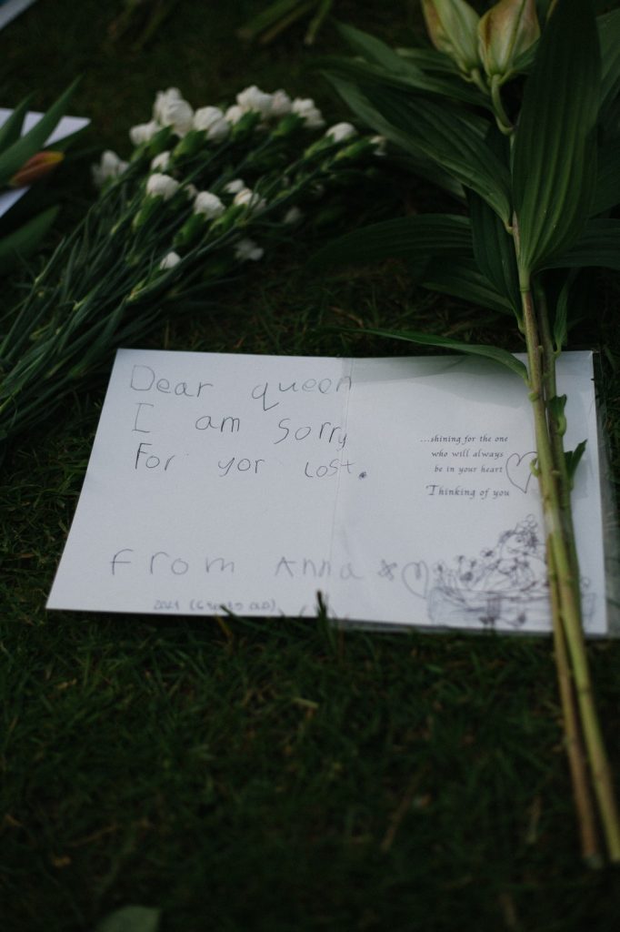 A note and flowers on the ground at Windsor Castle.