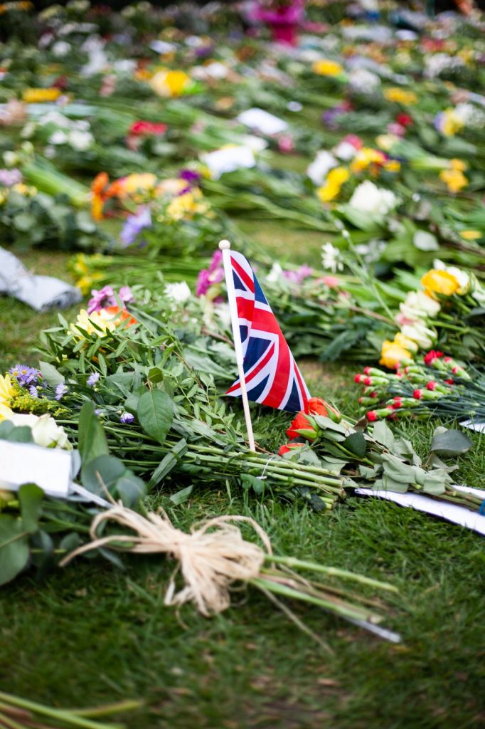 A note, flowers and a small Union flag on the ground at Windsor Castle.