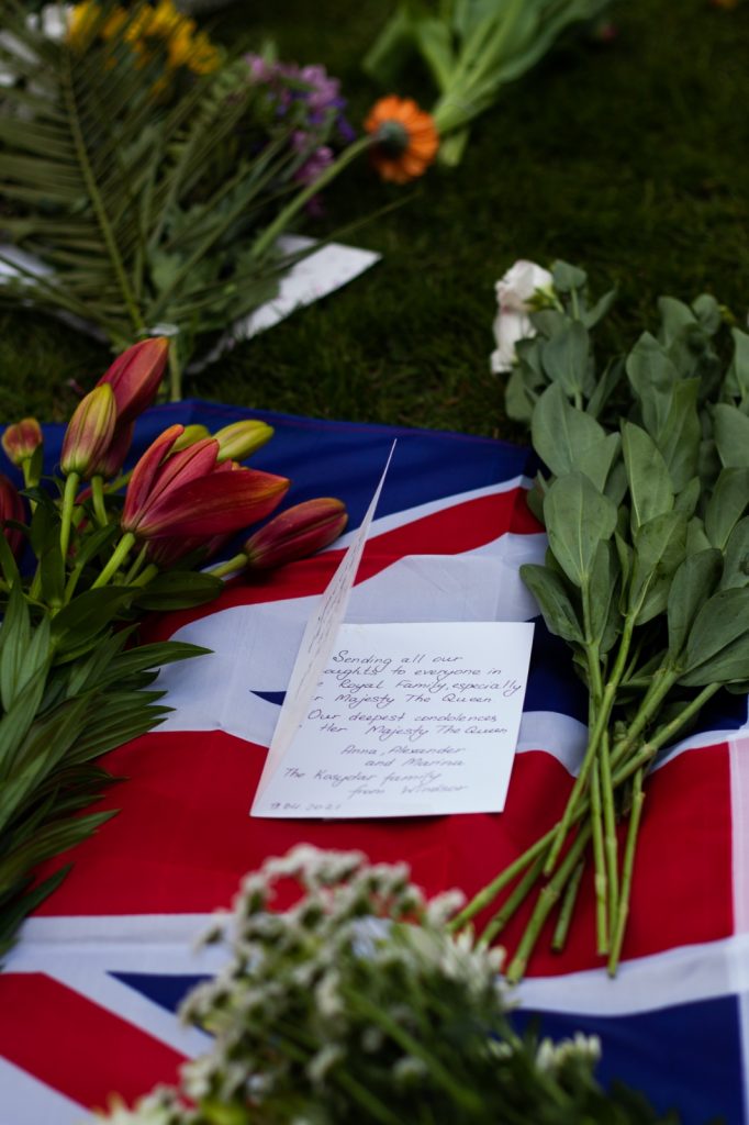 A note and flowers on a Union flag on the ground at Windsor Castle.