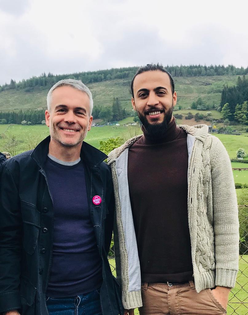 Picture of Jon and Yusuf in a rural setting. Both are happy and smiling. 