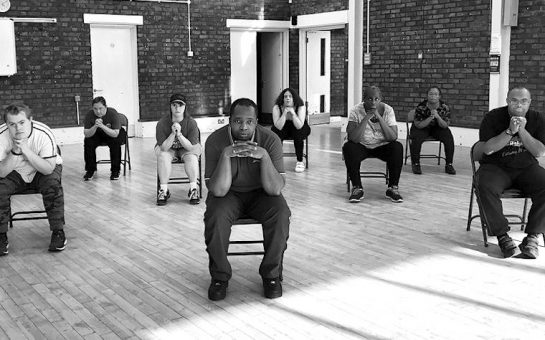 Members of the Baked Bean Company sitting on chairs spaced apart