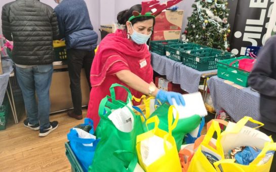 Rita wears reindeer antlers whilst preparing food packages on Christmas Day