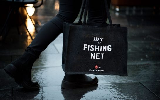 a person carrying a sticks n sushi bag