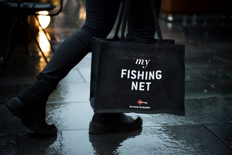 a person carrying a sticks n sushi bag