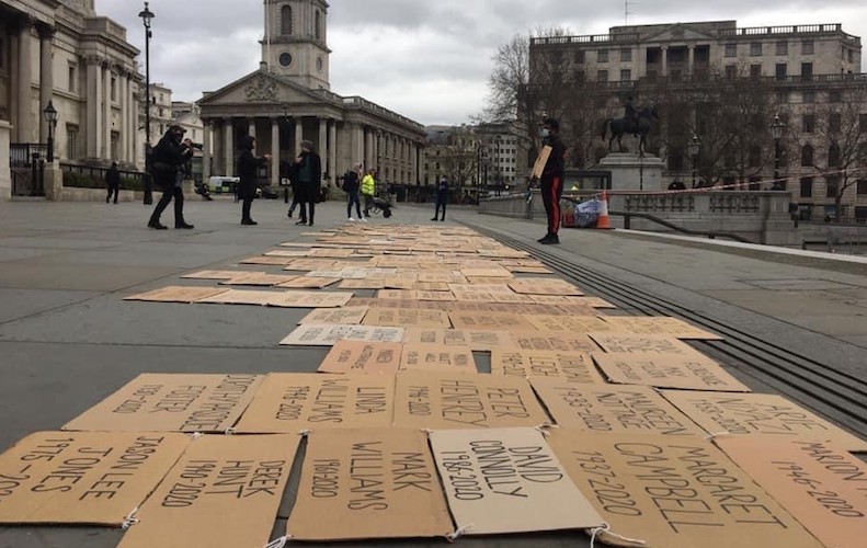 A number of cardboard headstones have been tied together on the floor in Trafalgar Square creating a makeshift headstone