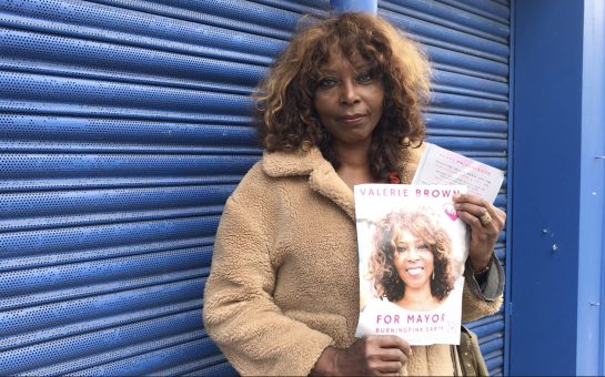 Valerie Brown Burning Pink Party Mayoral Candidate holds up her poster for upcoming elections