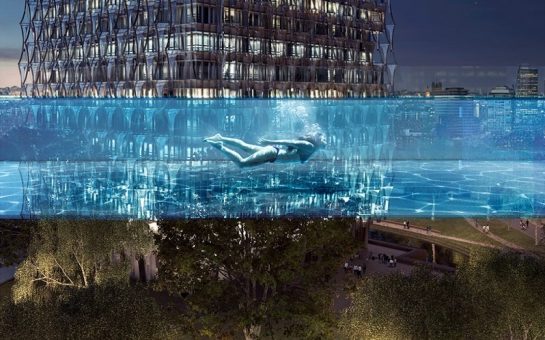 person swimming in the sky pool at night