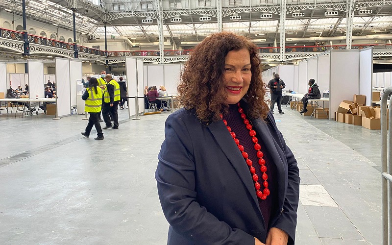 leonie cooper in a blue blazer and red jewellery