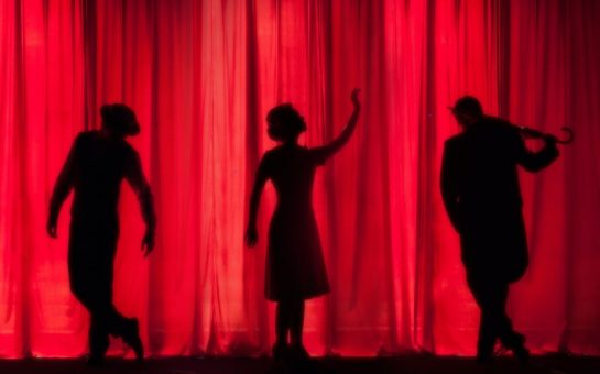 Performers in silhouette on stage