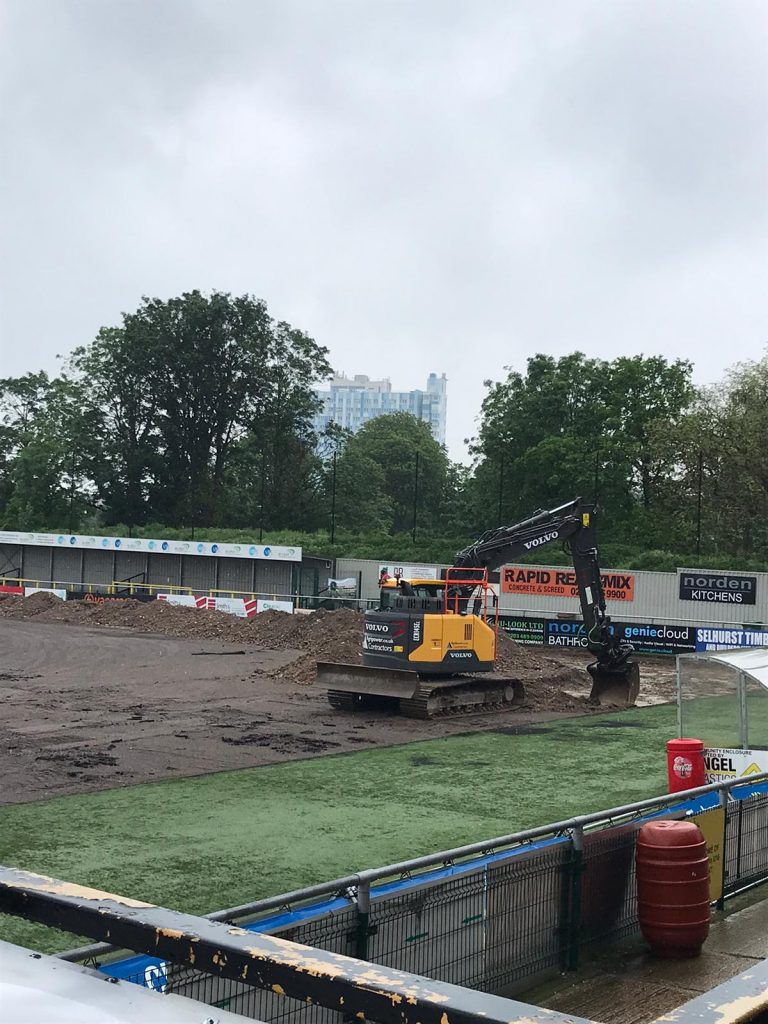 Image of digger removing the astro turf from the pitch. 